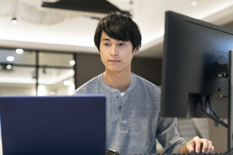 PCで作業をする若い男性