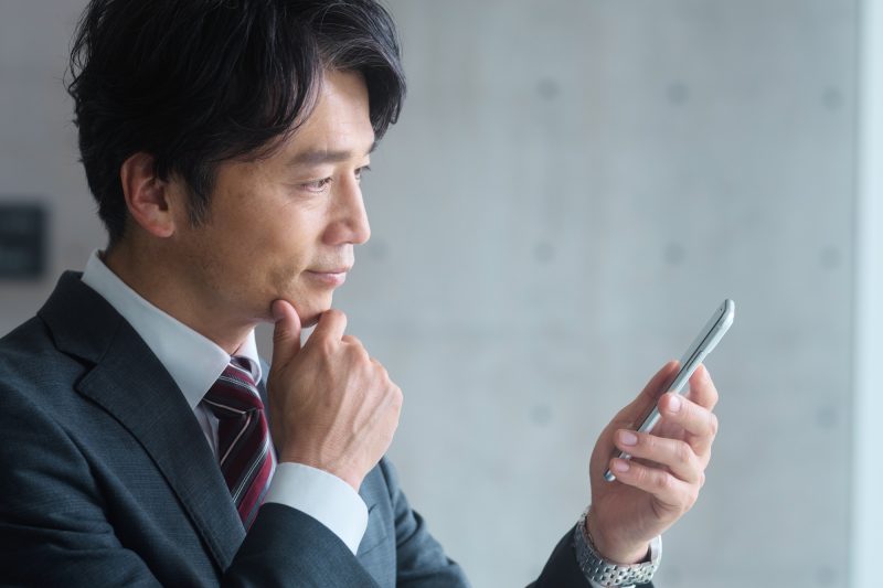 スマホ/男性/考える/悩む/40代/50代/スーツ